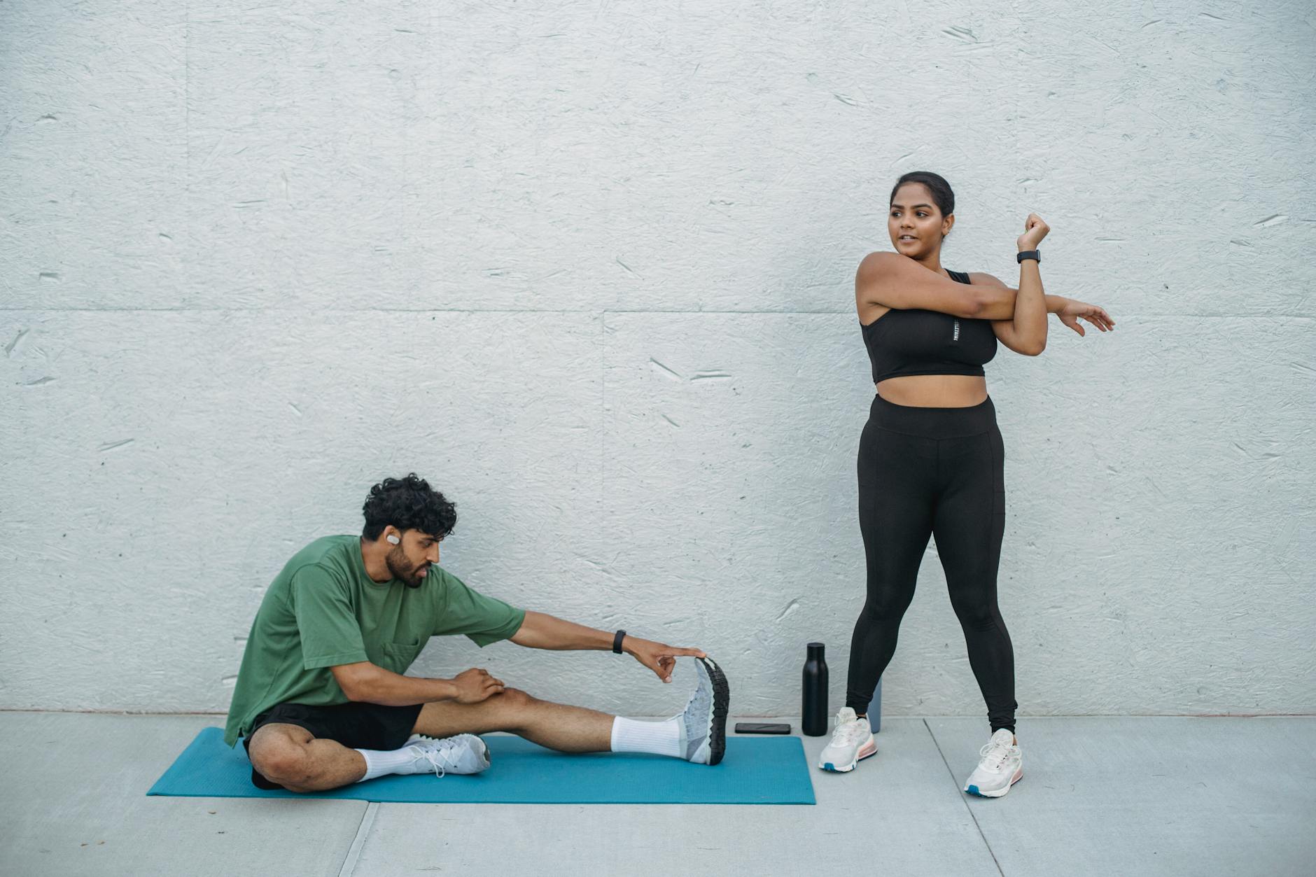Para rozciągająca się na świeżym powietrzu podczas treningu fitness