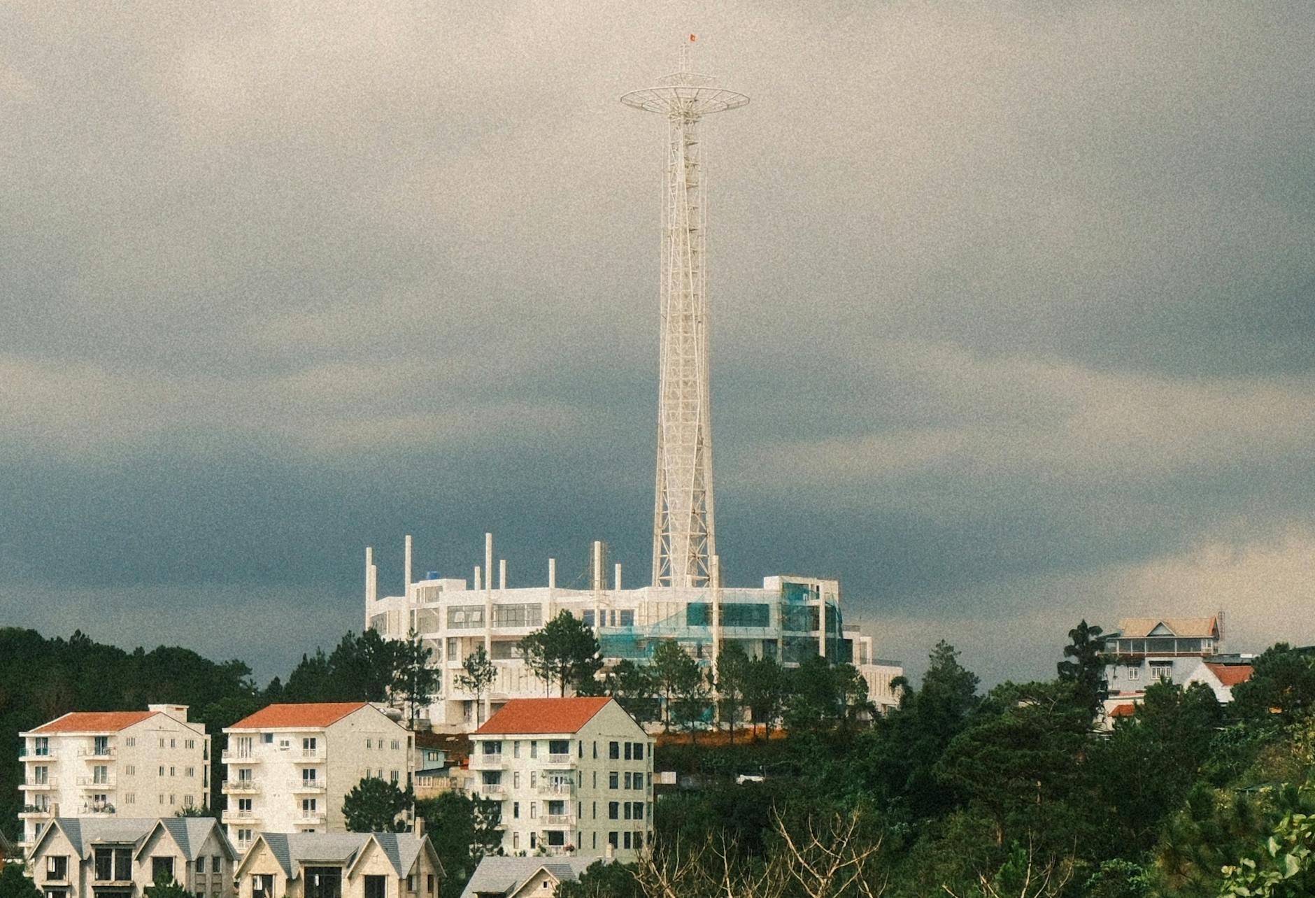 Wysoki wieżowiec na tle nowoczesnych budynków i dramatycznego nieba