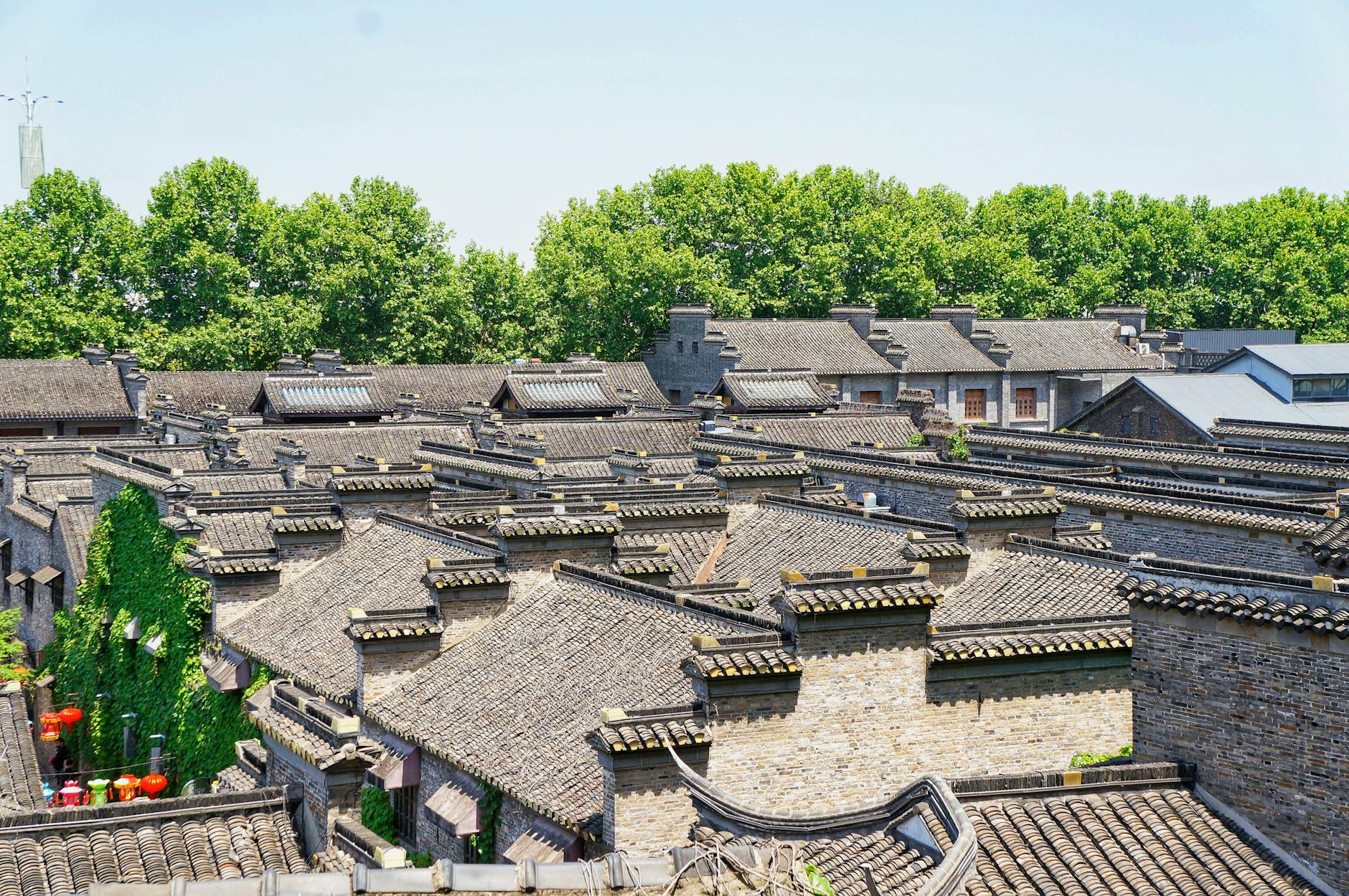 Letnie ujęcie tradycyjnych chińskich dachów wśród bujnej zieleni