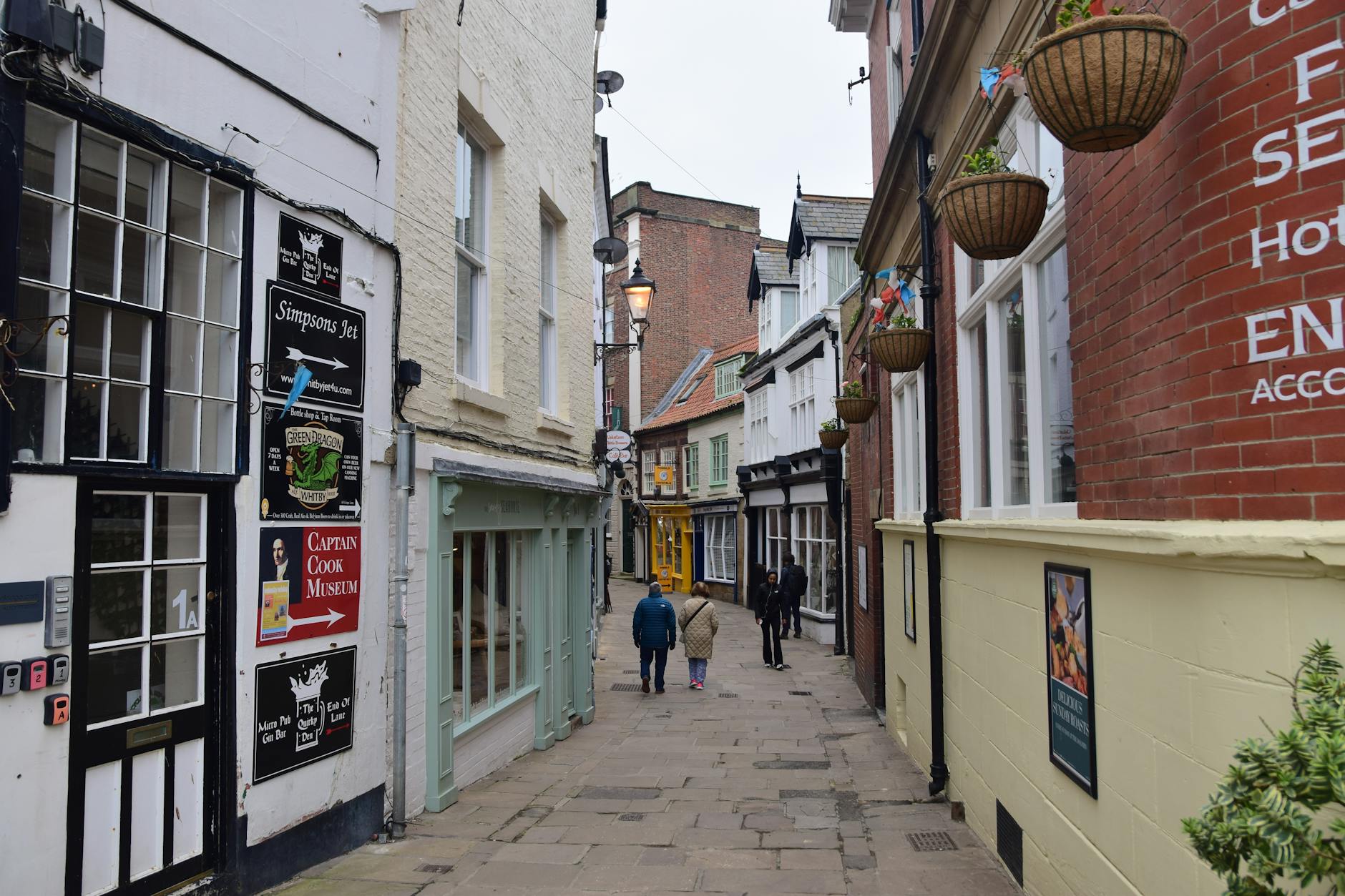 Wąska brukowana uliczka w Whitby z zabytkowymi kamienicami i sklepikami