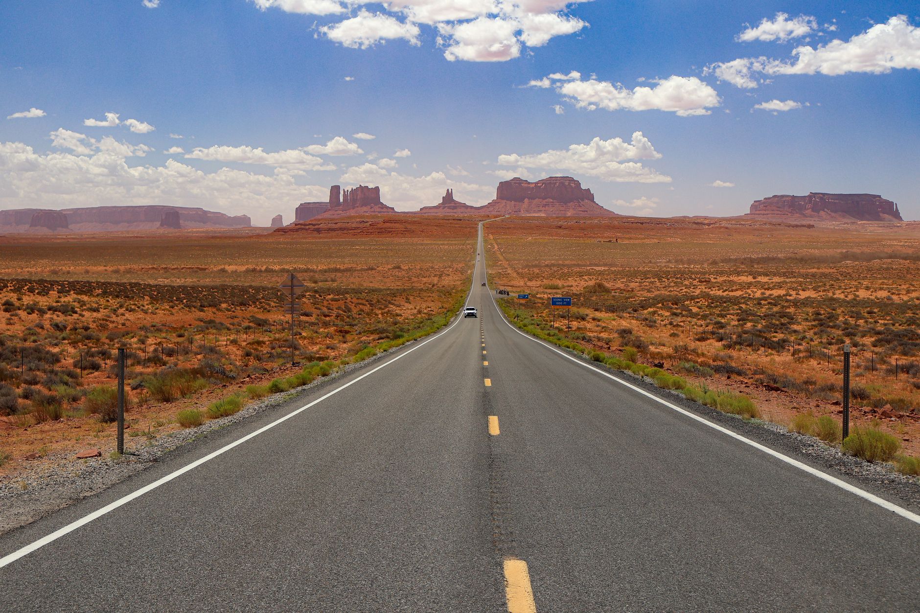 Najpiękniejsze trasy widokowe w USA, które zrobisz zwykłym autem Pusta autostrada przez Monument Valley pod błękitnym niebem